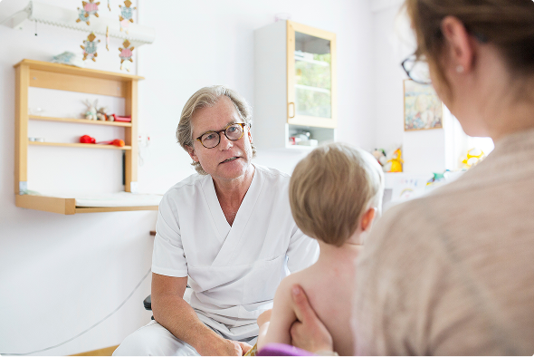 Kinderarts die meningitis door meningokokken uitlegt aan moeder en kind Kinderarts die meningitis door meningokokken uitlegt aan moeder en kind